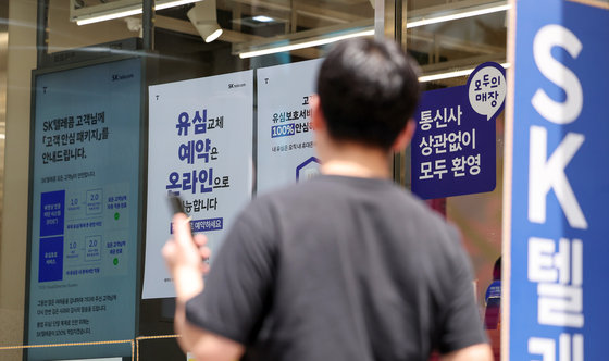 A passerby walks in front of an SK Telecom store in Seoul on May 26. [NEWS1]