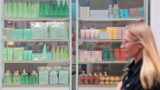 Cosmetics are stocked at the storefront window of a shop in Myeong-dong, central Seoul, on May 6. [YONHAP] 