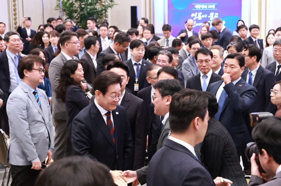 President Lee Jae Myung, center, greets reporters after his first formal press conference marking 30 days in office at the Blue House compound in central Seoul on July 3. [JOINT PRESS CORPS]
