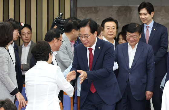 Rep. Song Eon-seog, emergency committee interim leader and floor leader of the conservative People Power Party, center, greets lawmakers ahead of a party meeting at the National Assembly in western Seoul on July 3. [YONHAP]