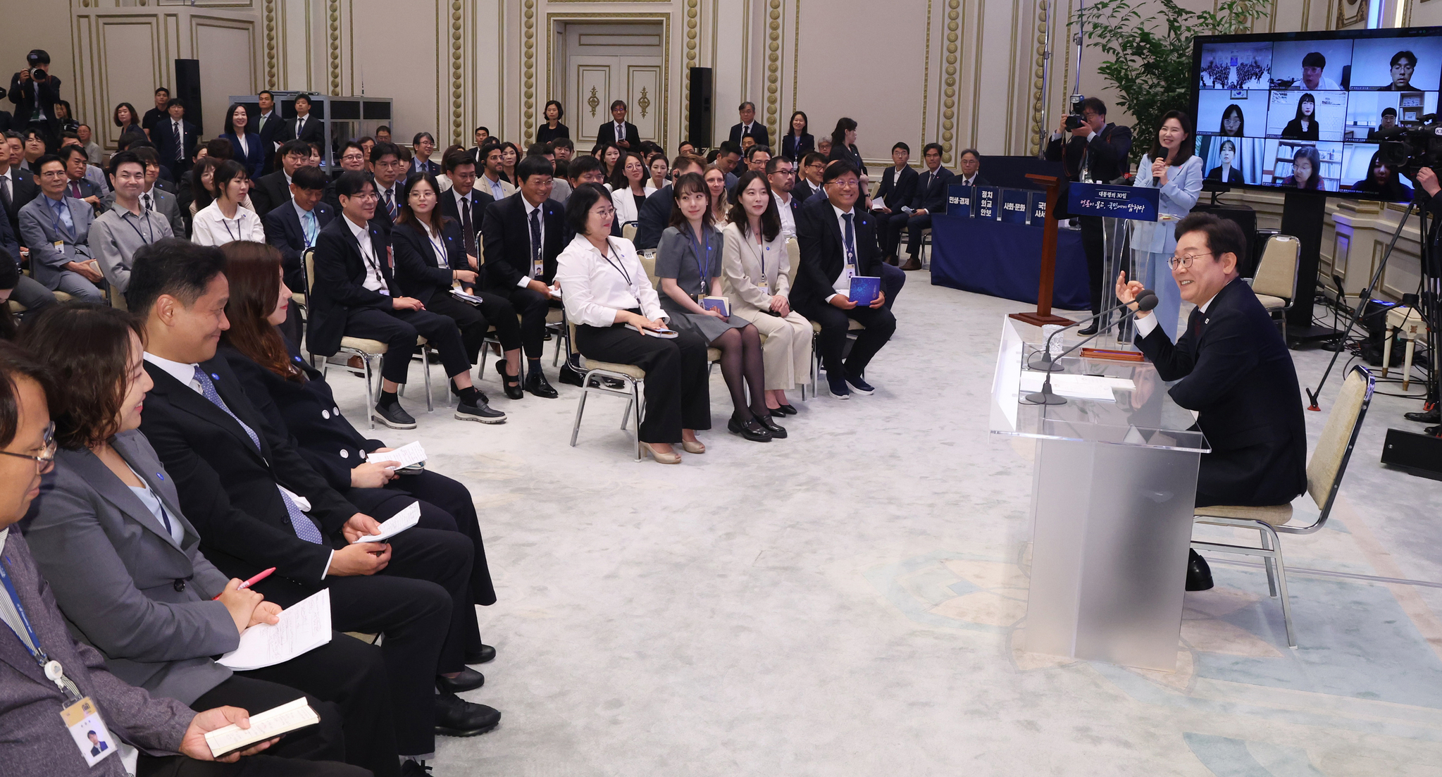 President Lee Jae Myung, right, chats with journalists during a press conference marking his first 30 days in office at the Blue House’s Yeongbingwan state guest house in central Seoul on July 3. [JOINT PRESS CORPS]
