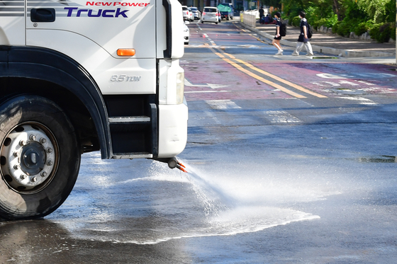 A sprinkler truck sprays water on a road in front of the Pohang International Exhibition & Convention Center (POEX) in Pohang, North Gyeongsang on July 3. [NEWS1]