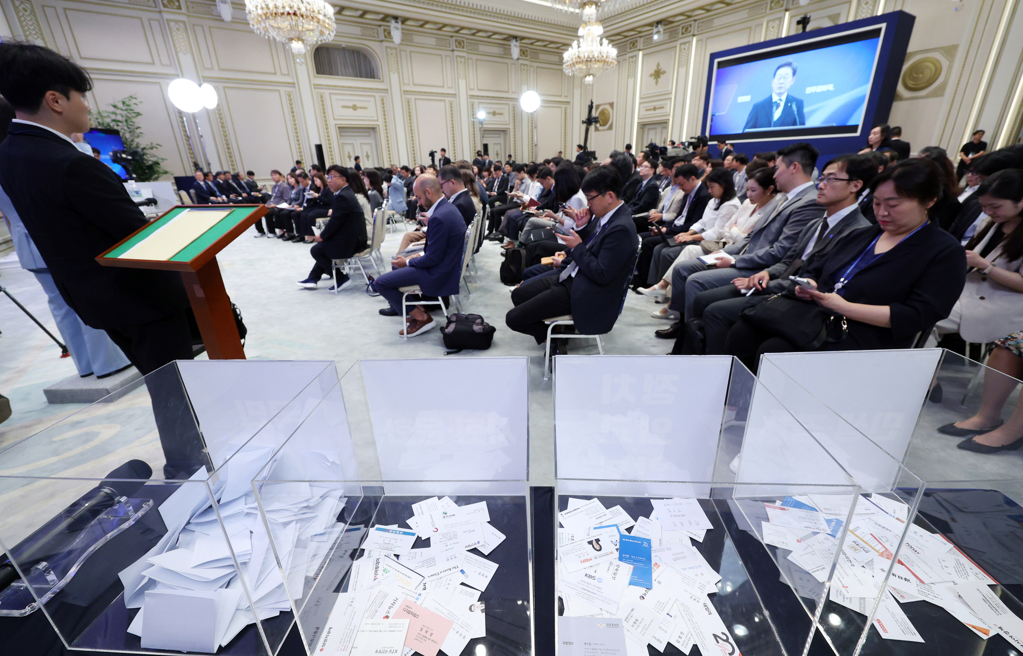 Journalists’ business cards are seen in raffle boxes divided by the themes of President Lee Jae Myung’s first formal press conference at the Blue House’s Yeongbingwan state guest house in central Seoul on July 3. The business cards were randomly drawn during the town hall meeting to select journalists to ask questions to the president. [JOINT PRESS CORPS]