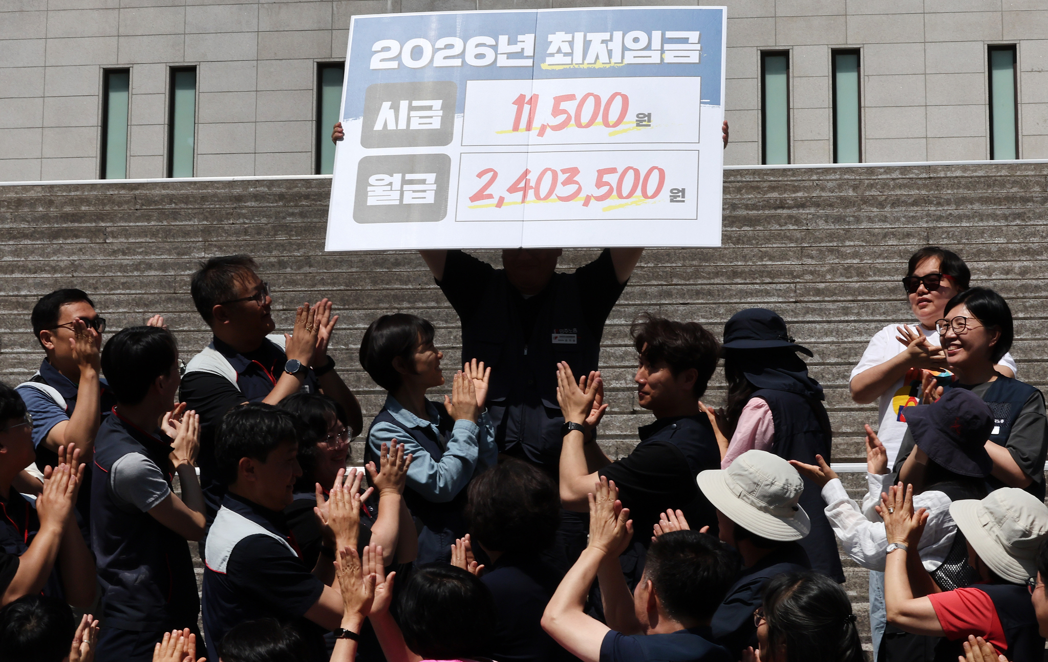 Members of the Minimum Wage for All campaign hold a press conference and performance on the steps of the Sejong Center for the Performing Arts in Jongno District, central Seoul, on the morning of June 11. They are calling for the hourly minimum wage to be raised to 11,500 won ($8.50) next year, a 14.7 percent increase from this year’s rate of 10,030 won. [NEWS1]