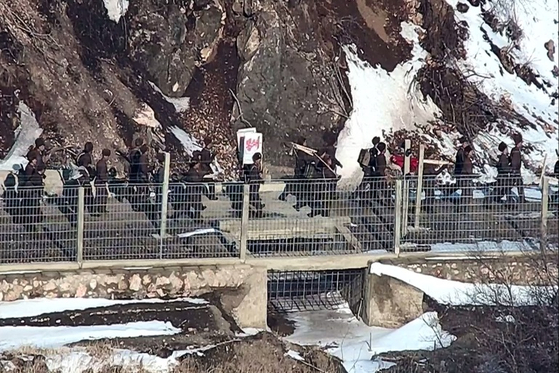 North Korean soldiers carry tools and a sign reading “Blockade” as they move near a guard post along the western front on March 27. [JOINT CHIEFS OF STAFF] 