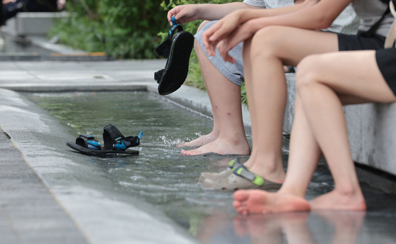 Citizens cool themselves down at the Gwanghwamun Square in central Seoul on July 1. [YONHAP]