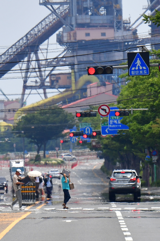 Citizens walk across a heated road in Pohang, North Gyeongsang, on July 1. [NEWS1]
