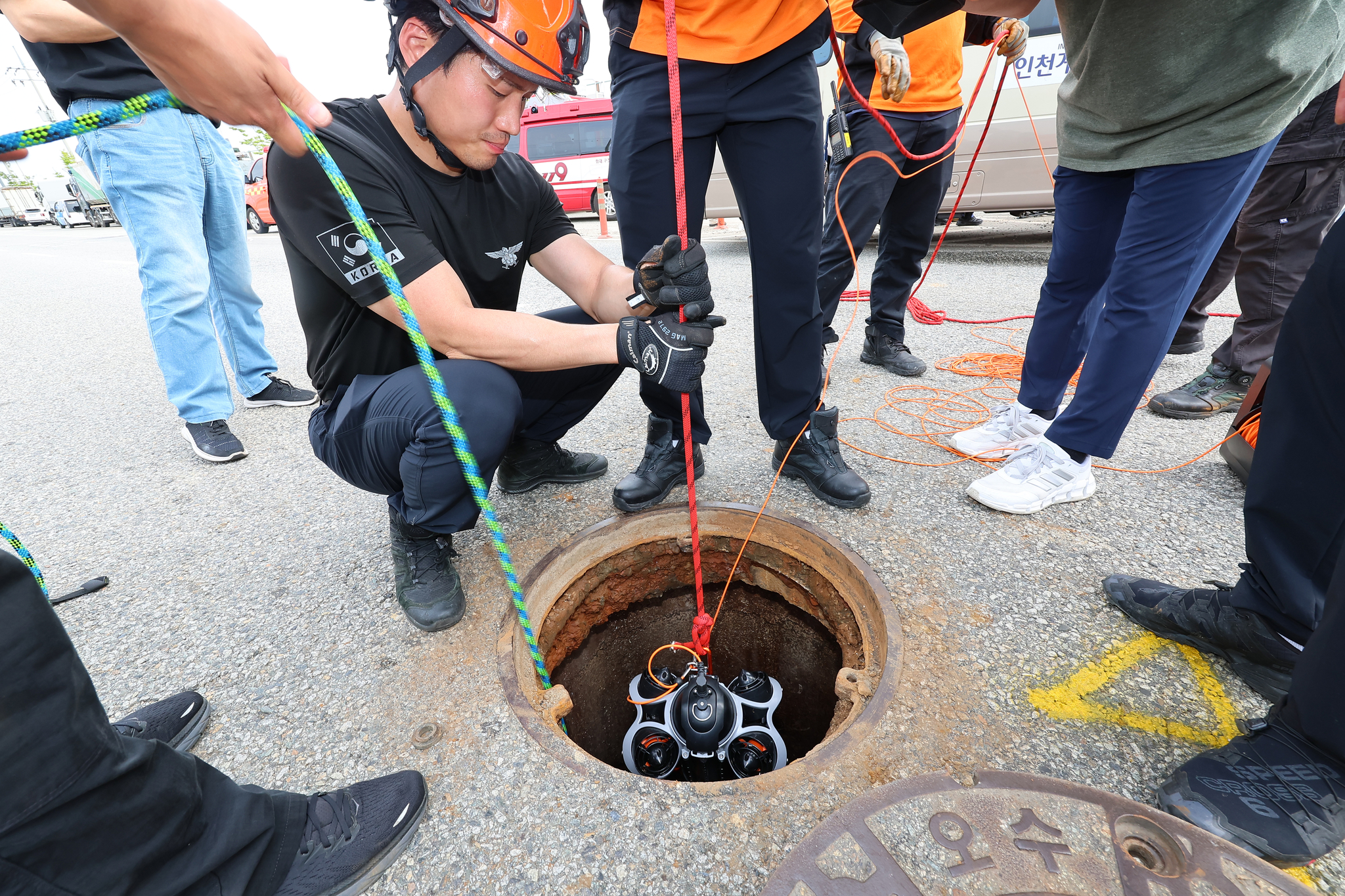 The rescue team from the Gyeyang Fire Station inserts an endoscopic camera into a manhole on a road in Gyeyang District, Incheon, on July 6 to search for a worker who went missing inside. [YONHAP]  