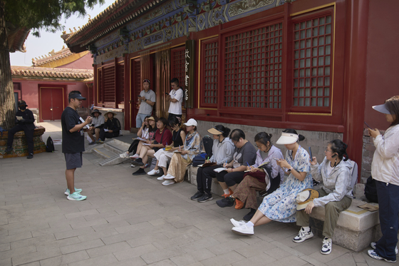 Tour guide Jim trains a group of tour guides transitioning from Chinese-only to English tours at the Forbidden City in Beijing on June 18. [AP/YONHAP]