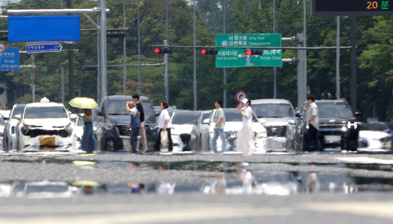 A haze rises above a road in Yeouido, western Seoul, as a heat advisory was issued on July 8. [YONHAP] 
