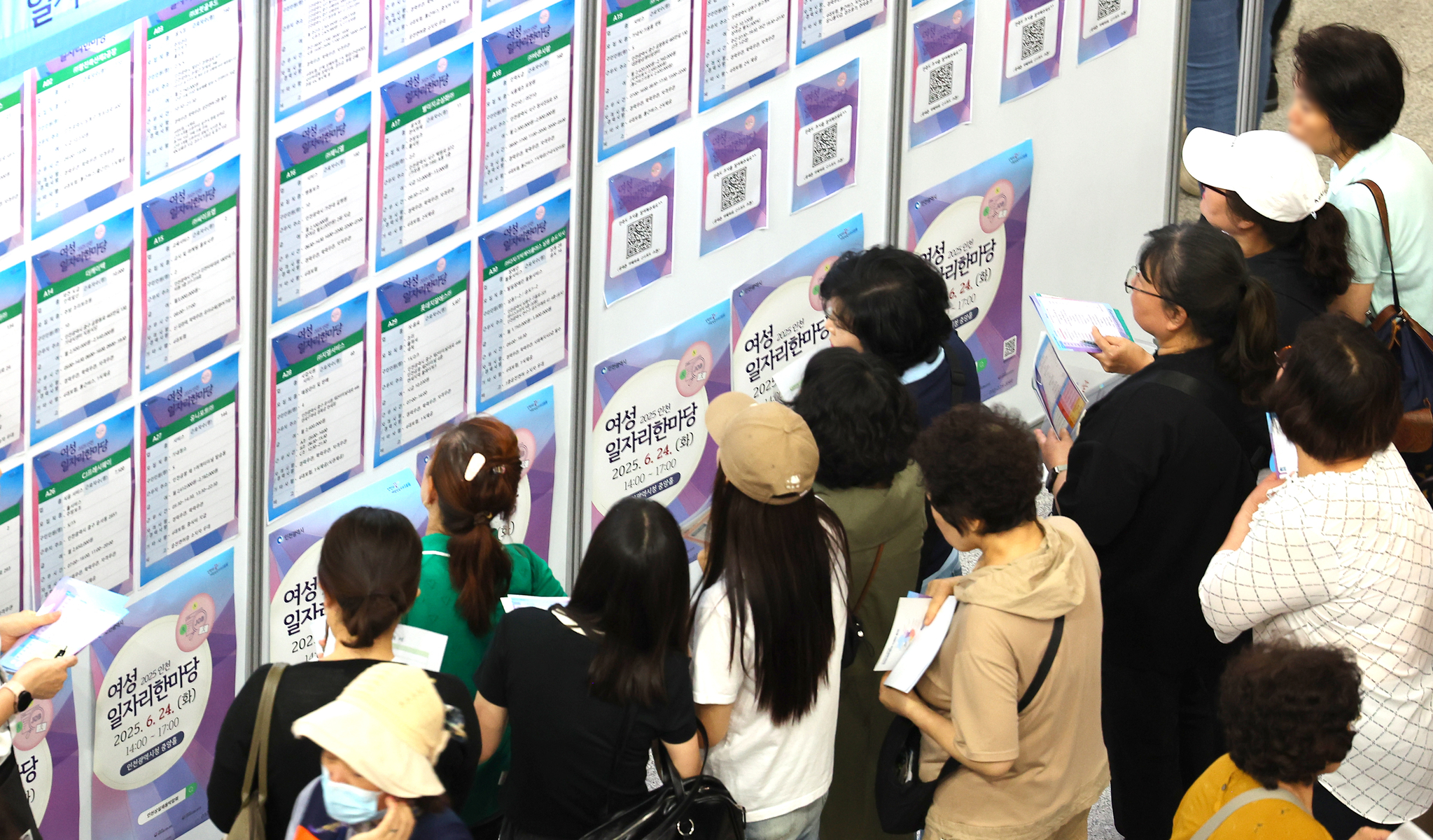 Job seekers look at notices at a job fair held in Incheon on June 24. [YONHAP]