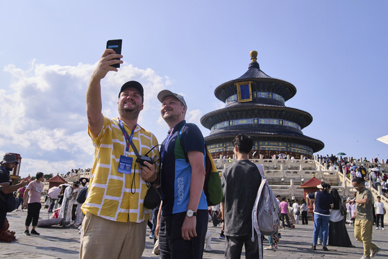 Tourists take a selfie at the Temple of Heaven as they take a half-day tour offered by travel agency Trip.com Group in Beijing on June 15. [AP/YONHAP]