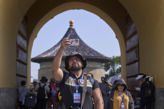 Georgi Shavadze, a Georgian living in Austria, takes a smartphone photo at the Temple of Heaven during a half-day tour by travel agency Trip.com Group in Beijing on June 15. [AP/YONHAP]