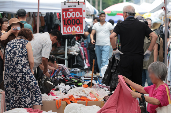 People shop for affordable products that cost below a dollar in a market in Dongdaemun District in eastern Seoul on July 6. [YONHAP]