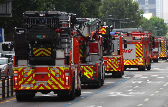 Fire trucks move down an urban street in this undated stock photo. [YONHAP]