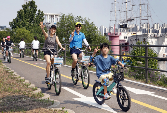 A family of three cycles as a part of the Seoul city government's triathlon festival in Ttukseom Hangang Park in eastern Seoul on May 30. [PARK SANG-MOON]