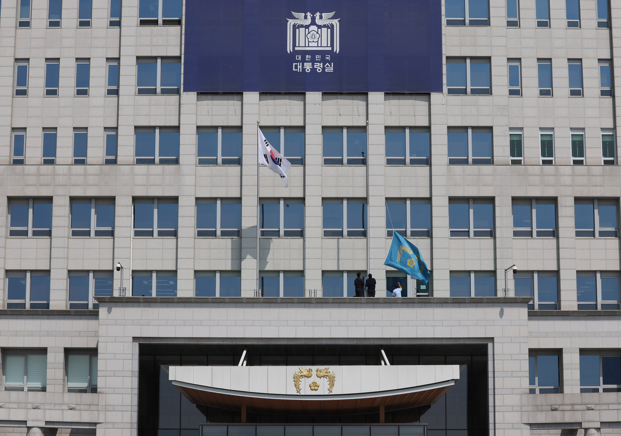 Officials lower the phoenix flag, symbolizing the presidential office, at the Yongsan presidential compound in central Seoul on April 4, following the Constitutional Court's decision to remove impeached President Yoon Suk Yeol from office. [JOINT PRESS CORPS] 