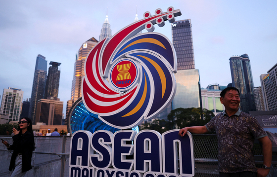People pose with the Association of Southeast Asian Nations (Asean) logo against the backdrop of Kuala Lumpur's skyline, ahead of the Asean Foreign Ministers' Meeting in Kuala Lumpur, Malaysia, on July 8. [REUTERS/YONHAP]