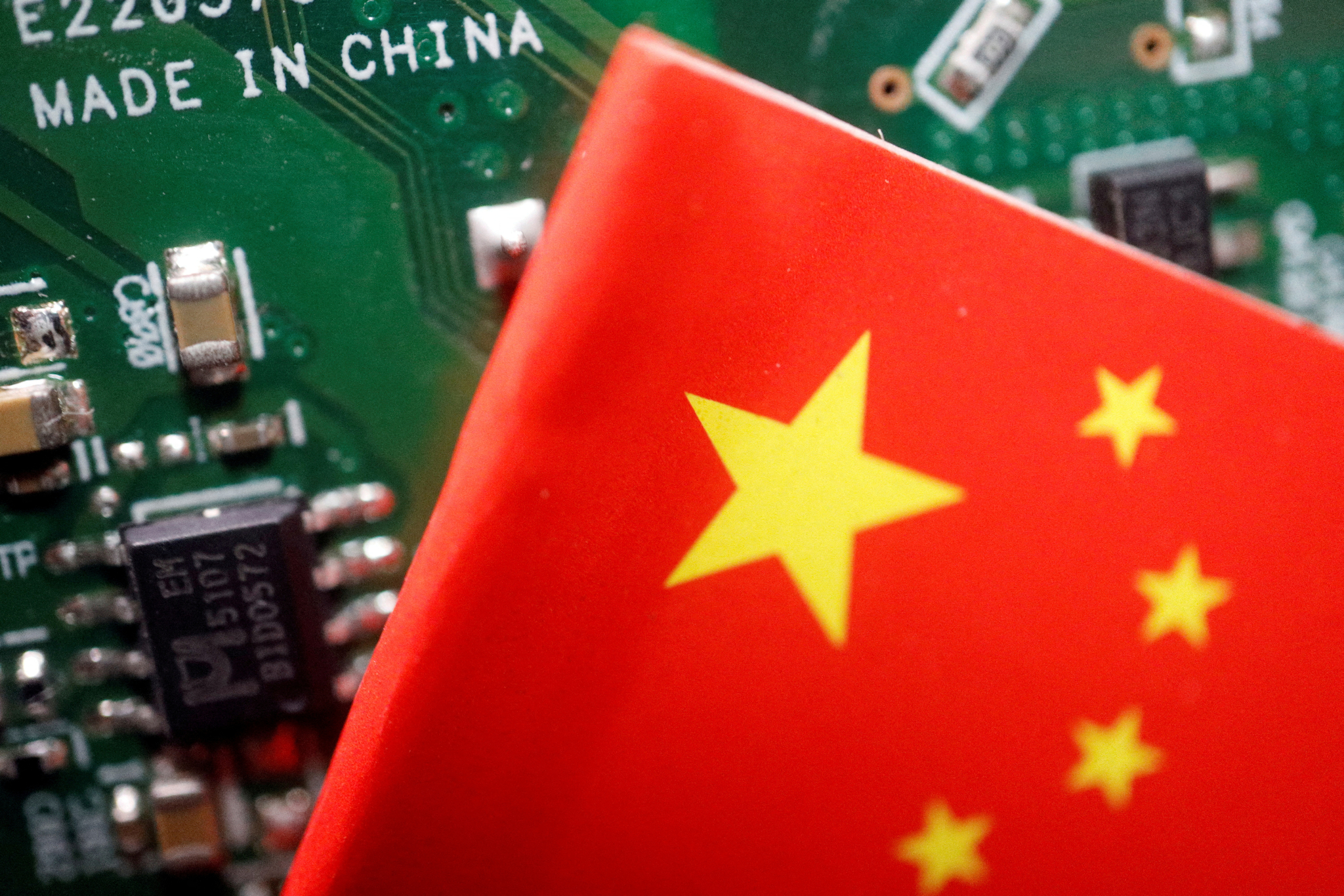 A Chinese flag is displayed next to a ″Made in China″ sign seen on a printed circuit board with semiconductor chips, in this illustration picture taken Feb. 17, 2023. [REUTERS/YONHAP]