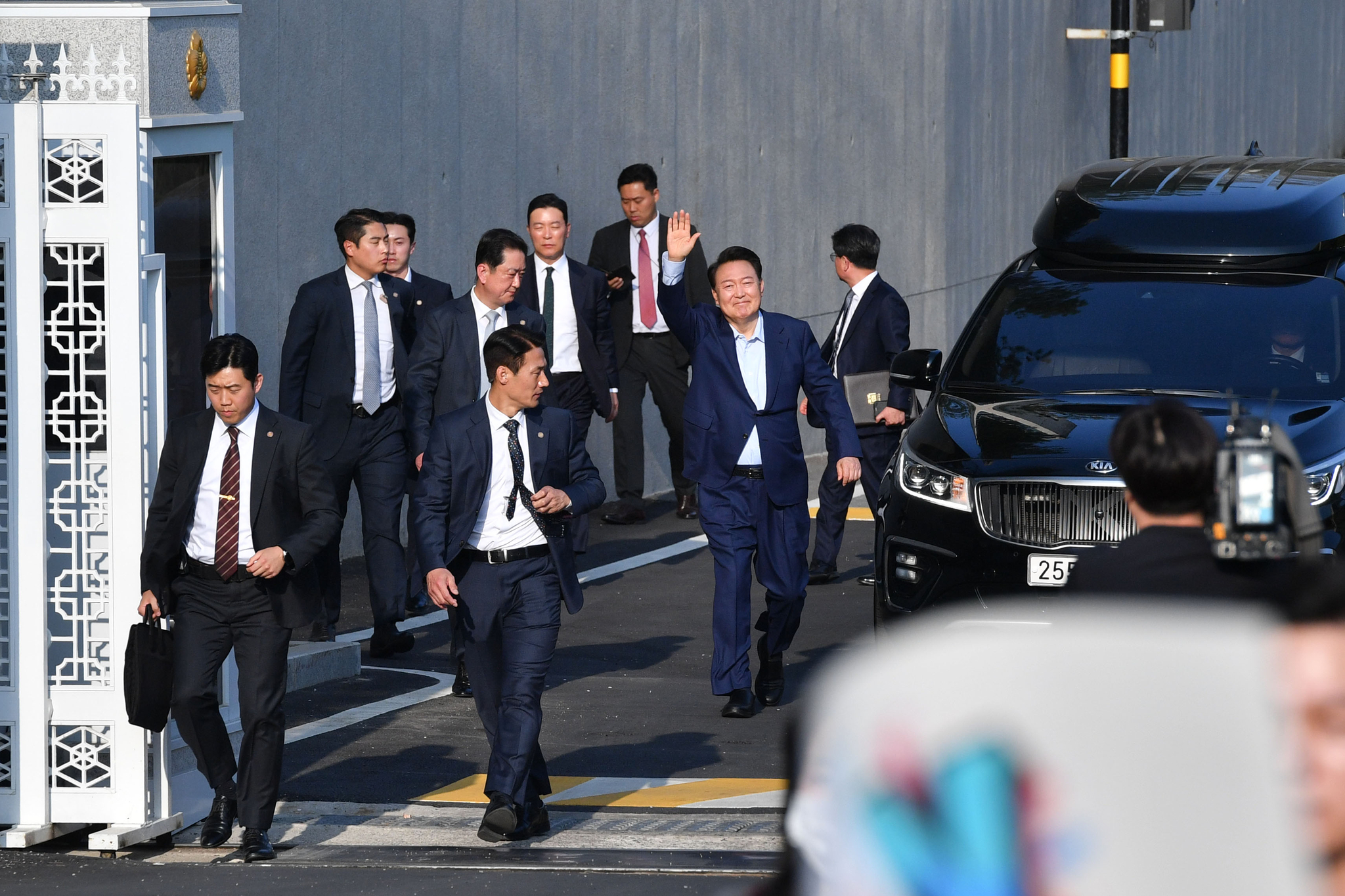Former President Yoon Suk Yeol, center, waves to as he leaves the official presidential residence in Hannam-dong, Yongsan District, in central Seoul on April 11, one week after he was removed from office. [JOINT PRESS CORPS]