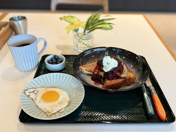 French toast with blueberry compote and white cream and a sunny-side-up egg are served for breakfast at Surak Hyu in Nowon District in northern Seoul on June 29. [LEE SOO-JUNG]