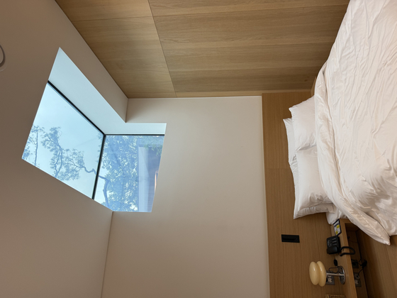 A skylight window is installed directly above a queen-sized bed in cottage No.1 at wellness village Surak Hyu in Nowon District, northern Seoul, on June 28. [LEE SOO-JUNG]