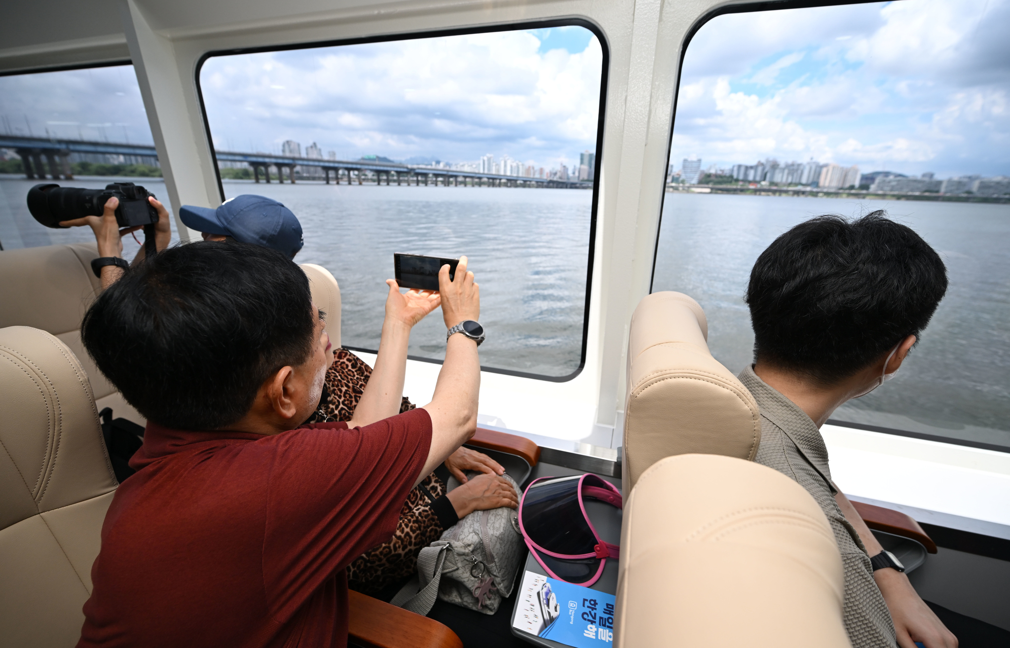 People take photos of the view from the Hangang Bus during the inaugural public ride on July 1. [JOINT PRESS CORPS] 