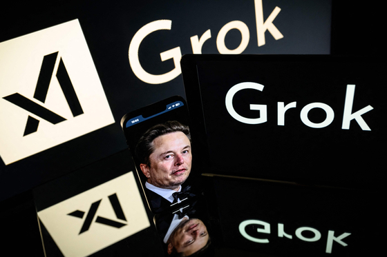 This photograph taken on Jan. 13 in Toulouse shows screens displaying the logo of Grok, a generative artificial intelligence chatbot developed by xAI, the American company specializing in artificial intelligence and it's founder South African businessman Elon Musk. [AFP/YONHAP]