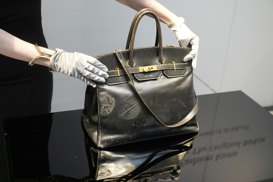 An auction officer displays the original Birkin bag created by Hermes for Jane Birkin in 1984, prior to its auction in Paris on July 10. [AP/YONHAP]