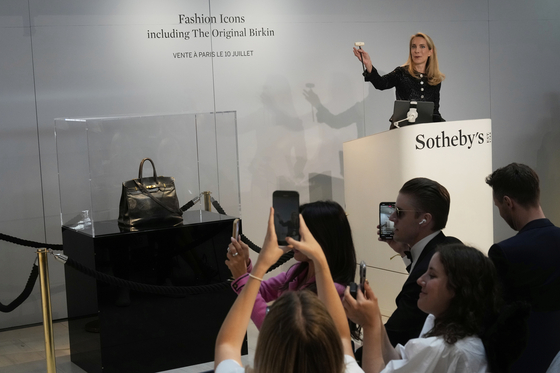 Auction officer Aurelie Vandevoorde gestures as the original Birkin bag created by Hermes for Jane Birkin was sold at auction for 7 million euros or $8.2 million in Paris on July 10. [AP/YONHAP]