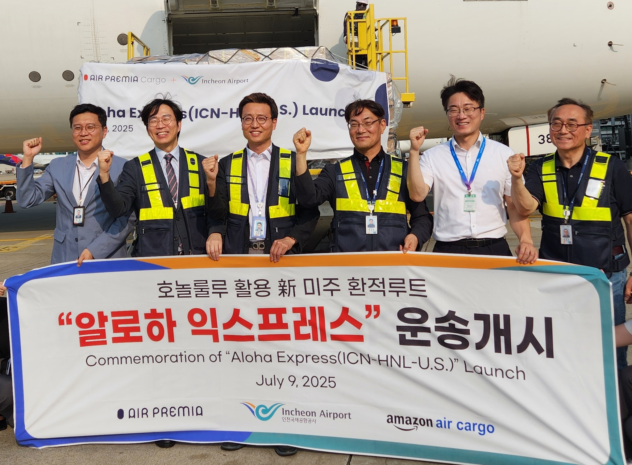 Kim Young-il, head of air cargo logistics at Incheon International Airport Corporation, third from left, and Kim Do-gil, head of Air Premia's cargo business, fourth from left, pose with officials in front of the first shipment through Aloha Express at Incheon Airport on July 9. [INCHEON INTERNATIONAL AIRPORT CORPORATION]
