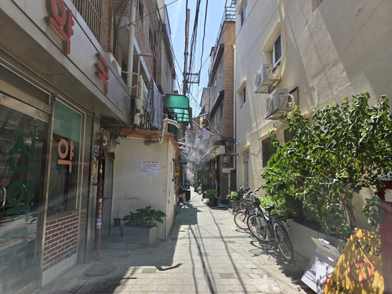 Sprinklers spray water on a street near a jjokbang (tiny subdivided room) village in Jongno District, central Seoul [SHIN HYE-YEON]