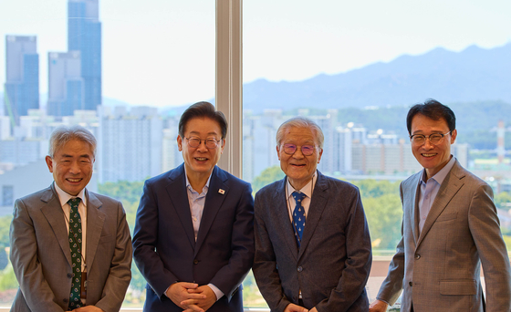 President Lee Jae Myung, second from left, poses for a photo with conservative critic Jeong Kyu-jae, left, during a luncheon meeting at the presidential office in central Seoul on July 11. [PRESIDENTIAL OFFICE]