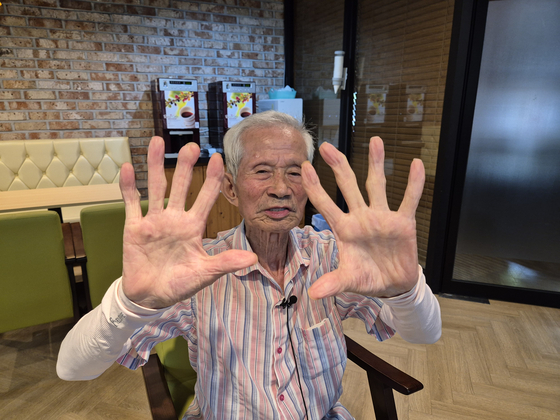 Lee Bu-yeol, a first-generation Hiroshima atomic bomb survivor, shows his twisted index and middle fingers while recounting his experience at the time of the bombing at the Hapcheon Atomic Bomb Victims Welfare Center in Hapcheon, South Gyeongsang on July 12. [JOONGANG ILBO]