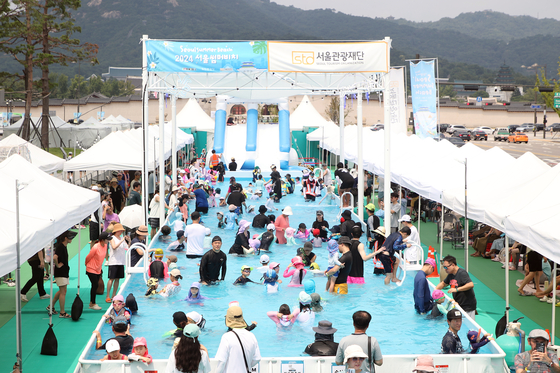 People enjoy the outdoor pool set up in Gwanghwamun Square for the Seoul Summer Beach festival in 2024. [SEOUL TOURISM ORGANIZATION] 