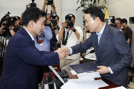 Defense Minister nominee Ahn Gyu-back hands over a pledge to Rep. Sung Il-jong during a confirmation hearing at the National Assembly in Yeouido, western Seoul on July 15. [JUN MIN-KYU]