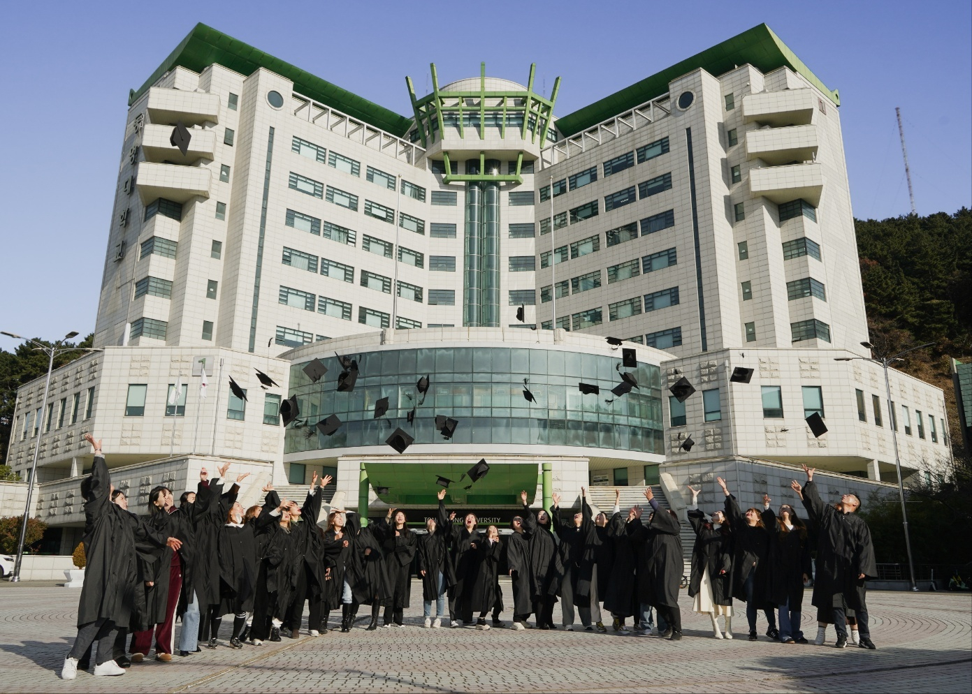 Students of Tongmyong University toss their graduation caps on the university’s campus. Tongmyong University announced it started a two-week hands-on training program for 16 international students on July 14. [TONGMYONG UNIVERSITY]