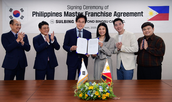 Sulbing CEO Kim Eui-yeol, third from left, and Beyond Bingsu Cafe Inc. CEO Winnie Go, fourth from left, pose for a photo after signing a master franchise agreement at Sulbing's headquarters in Seoul on July 14. [YONHAP]