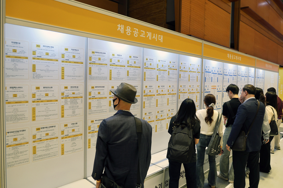 Jobseekers look at notices at a job fair held on May 26 in southern Seoul. [NEWS1]
