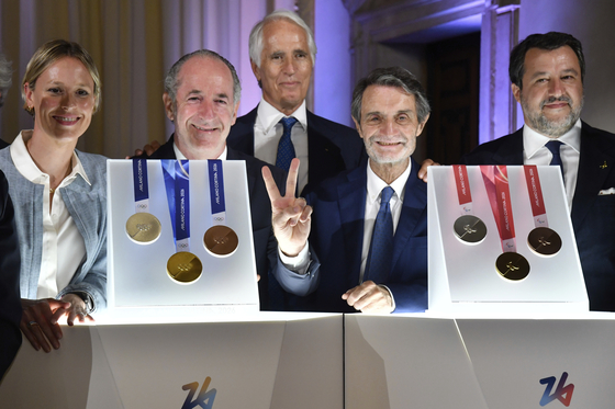 From left, former Italian swimmer Federica Pellegrini, Veneto region President Luca Zaia, Milano Cortina 2026 Foundation President Giovanni Malago, Lombardy region President Attilio Fontana and Italy's vice Premier Matteo Salvini pose for photographers next to Milano Cortina 2026 Winter Olympics and Paralympics medals during the unveiling ceremony in Venice, Italy, on July 15 [AP/YONHAP]