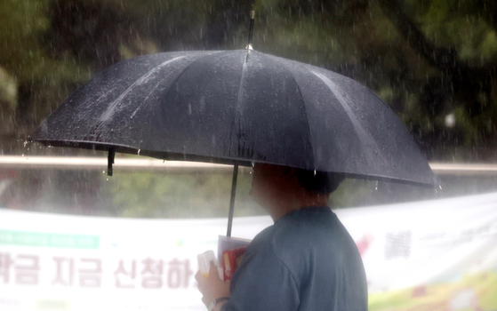 A person walks in the rain on the Jeonbuk National University campus in Jeonju, North Jeolla, on July 16. [NEWS1]