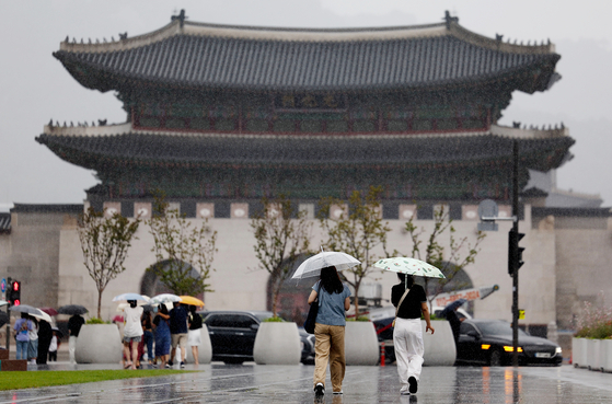 People walk in the rain under umbrellas on Gwanghwamun Square in Jongno District, central Seoul, on July 16. [YONHAP] 