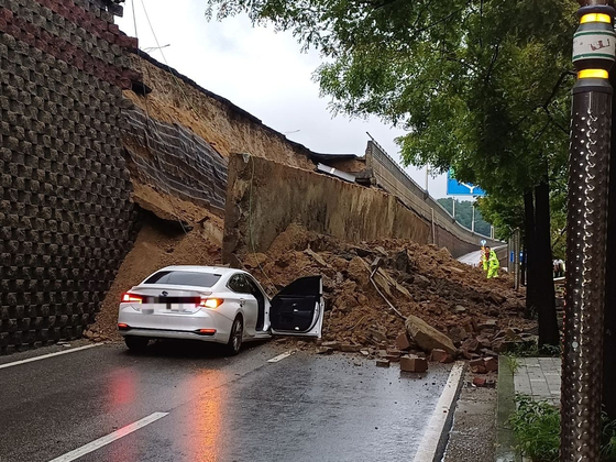 A vehicle is crushed under the collapsed retaining wall of the Gajang Overpass in Osan, Gyeonggi, on July 16. [YONHAP]