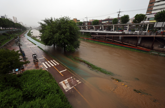 The Jeungsan Bridge in western Seoul is flooded on the morning of July 17. Access to nearby streams and the bridge have been prohibited due to the heavy rain. [YONHAP]