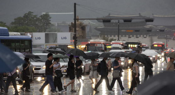 Citizens hurry home amid heavy rain on the evening of July 16, when heavy rain warnings were issued across the country. [YONHAP]