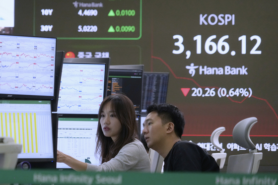 Currency traders watch monitors near a screen showing the Korea Composite Stock Price Index at the foreign exchange dealing room of the Hana Bank headquarters in central Seoul on July 17. [AP/YONHAP]