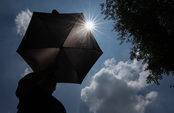 A local holds a sun umbrella in Seongdong District, eastern Seoul, on July 9, 2025. [NEWS1] 