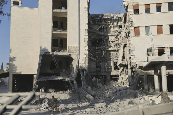 A soldier runs in front of the damaged Syrian Defense Ministry building allegedly hit by several Israeli airstrikes, in Damascus, Syria, July 16. [AP/YONHAP]