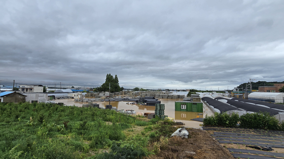 Homes and greenhouses are submerged by rising waters in Yesan County, South Chungcheong, on July 17. [SHIN JIN-HO]