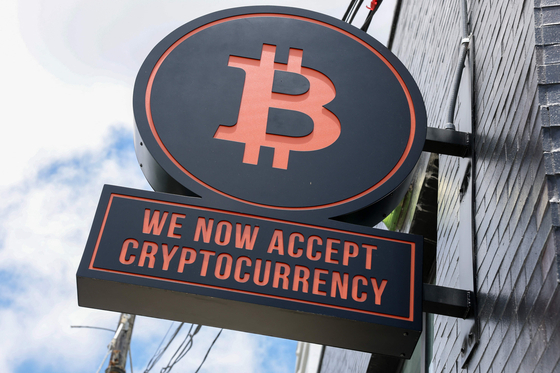 A Bitcoin sign is displayed on the wall of developers Ciprs and Rilea Group, who have sold a condominium unit in the Rider Residences, an under-construction project in Midtown Miami, using Bitcoin in a direct wallet-to-wallet transaction on July 16 in Miami, Florida. [AFP/YONHAP]